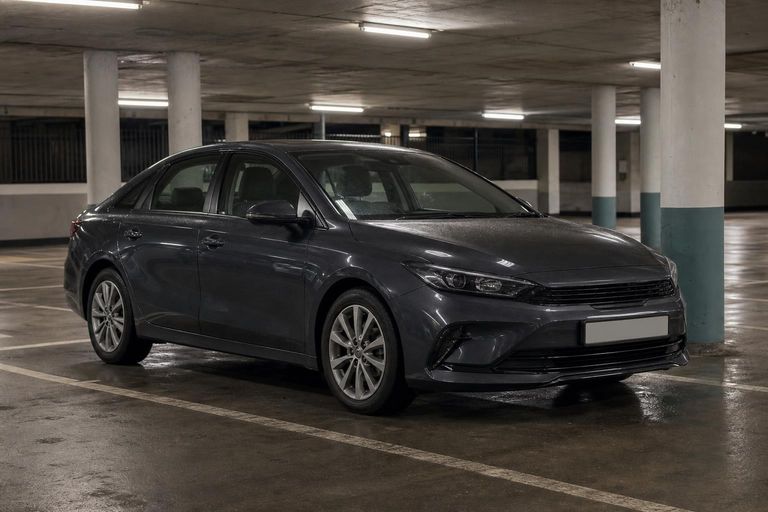 A dark grey family saloon parked in an underground car park.